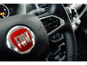 Alt tekst: Interieur van een Fiat buscamper met stuur en bedieningspanelen zichtbaar.